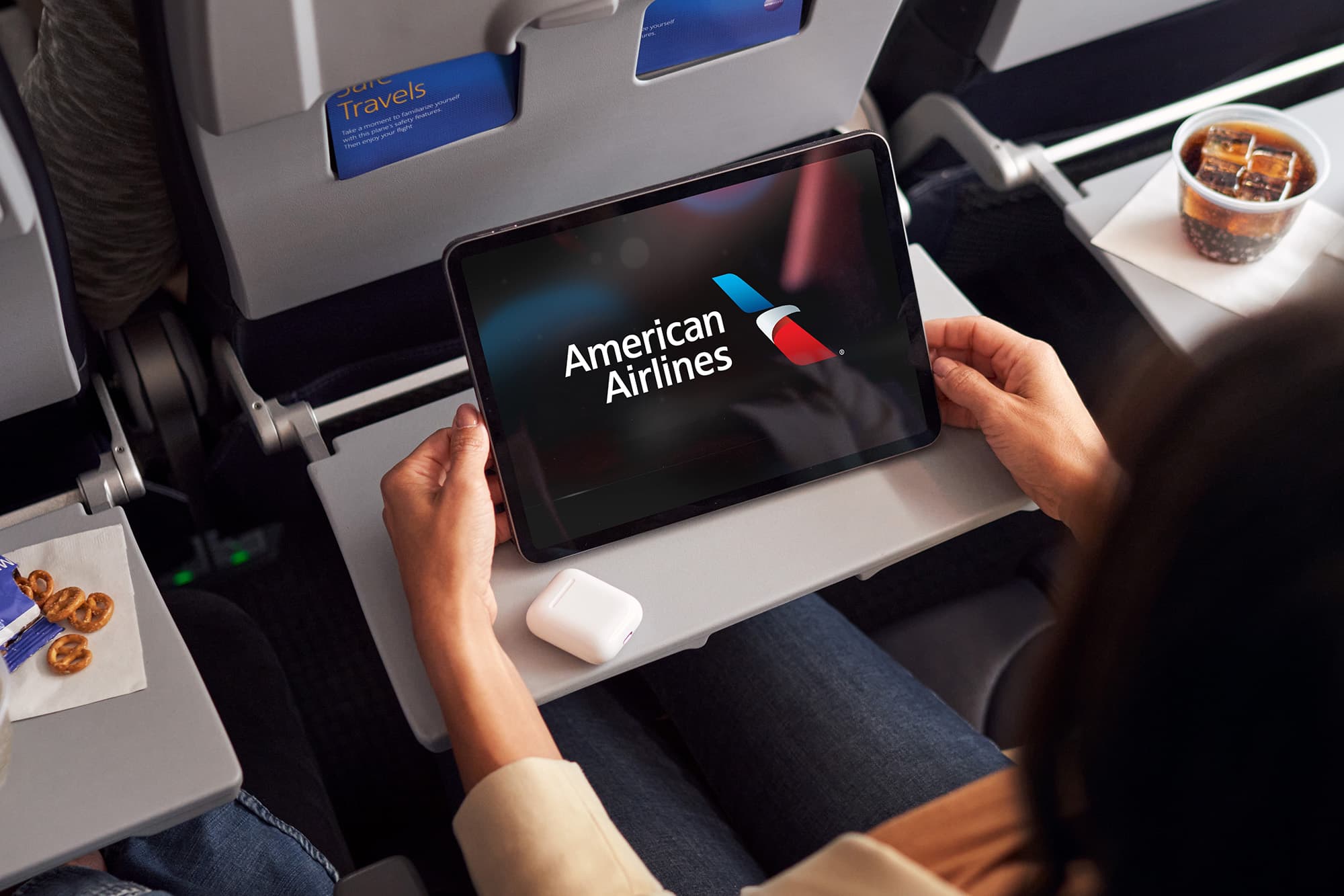 Woman using a tablet on an airplane fold up table